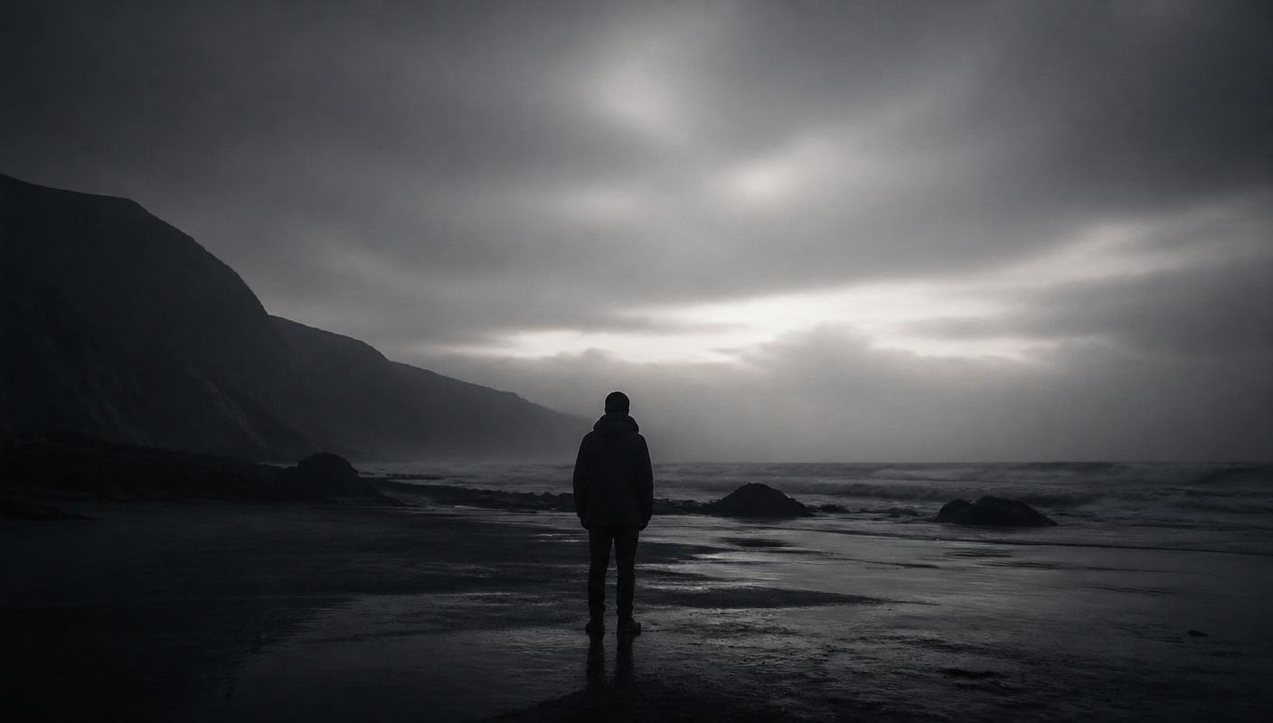 Lone figure on a misty shoreline at dusk